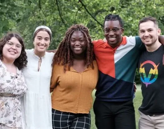 Five interns from the Oncology Summer Internship program. They are standing side by side in a green outdoor/park environment.