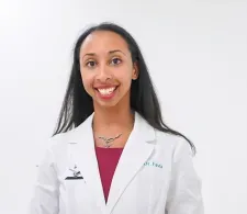 Dr. Favia Dubyk in a white coat. She is smiling facing forward against a clear background.