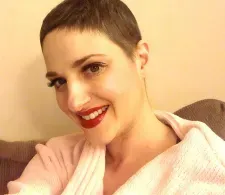 Melissa Berry during cancer treatment. She has shorter hair and is taking a selfie while smiling.