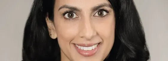 Dr. Lekha Mikkilineni smiling facing forward. She is wearing a black blazer and has long black hair.