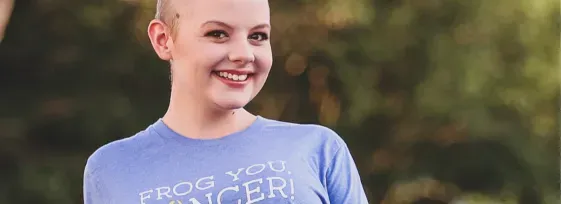 Auburn sitting criss-cross and smiling facing forward.
