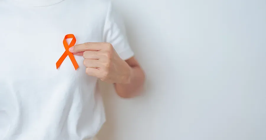 Person holding an orange ribbon