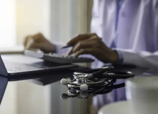 hands typing and stethoscope