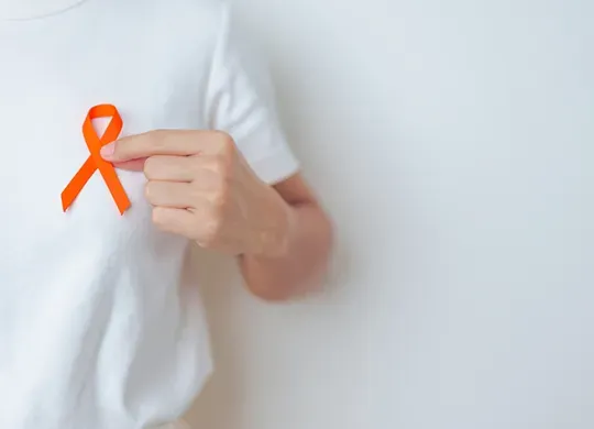 Person holding an orange ribbon