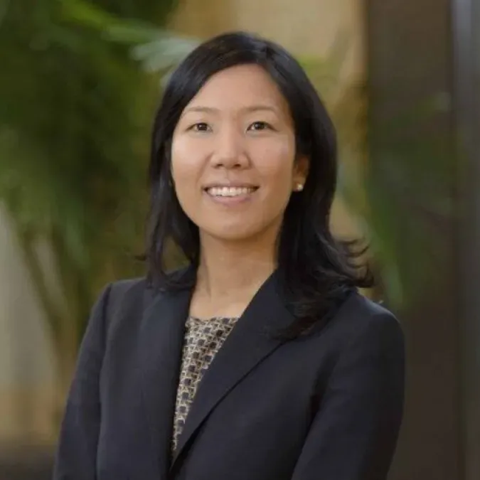 Headshot of Dr. Chrisann Kyi. She is smiling facing forward and wearing a black blazer and has shoulder-length black hair.